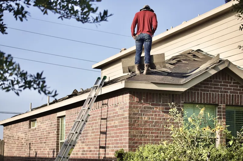 Professional roofer working on a residential roof in Thille